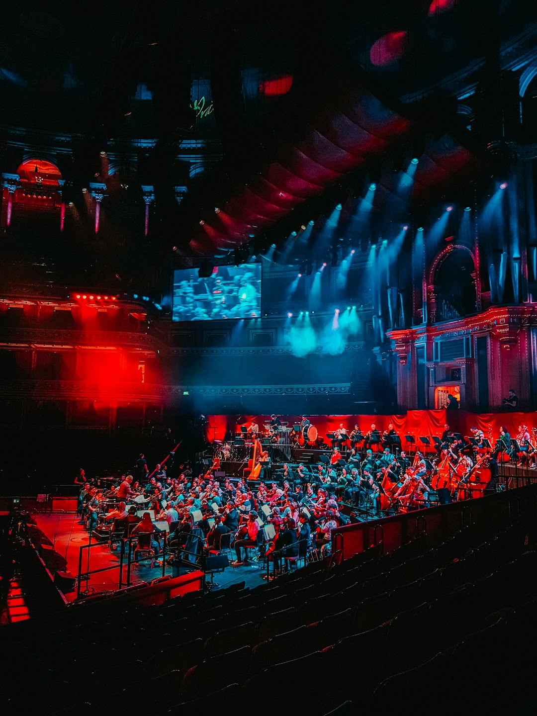Symfonický orchester hrá na pódiu veľkej koncertnej sály.